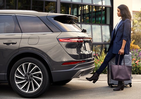 A woman with her hands full uses her foot to activate the available hands-free liftgate. | Lincoln Demo 1 in Wooster OH