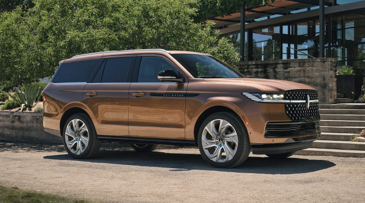 A 2025 Lincoln Black Label Navigator® SUV is parked in the driveway of a modern home.
