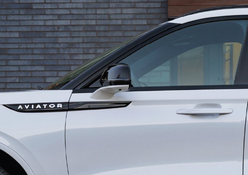 The driver’s side door and fender badging of a white 2026 Lincoln Aviator® SUV are showcased. | Lincoln Demo 1 in Wooster OH