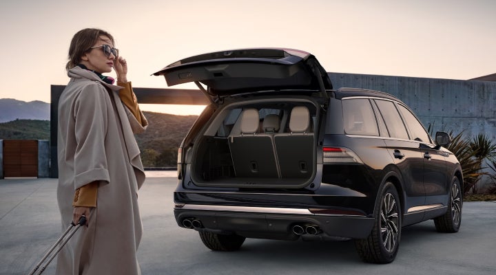 A woman approaches a 2026 Lincoln Aviator® SUV with its rear liftgate open. | Lincoln Demo 1 in Wooster OH